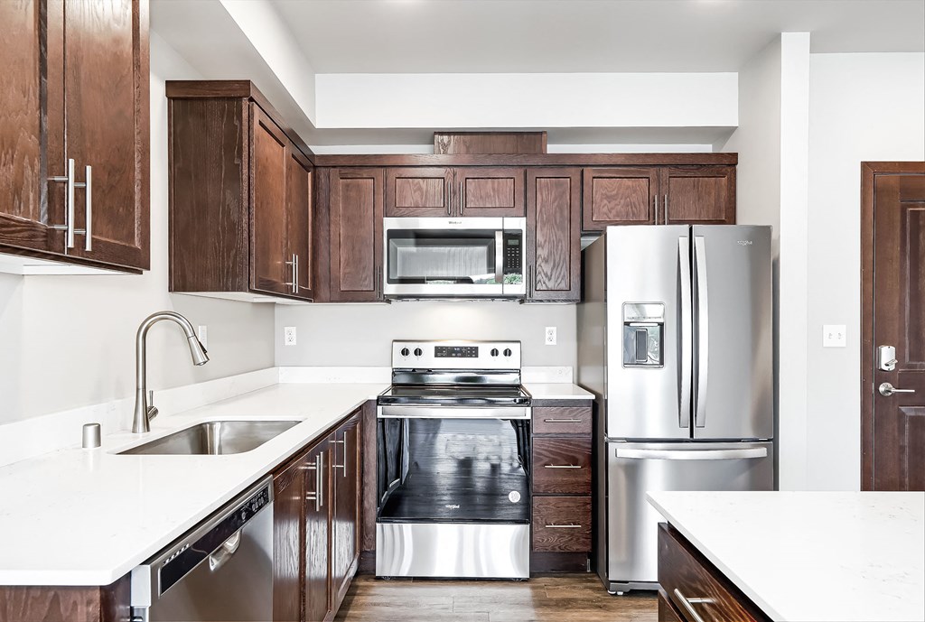 a kitchen with wooden cabinets and stainless steel appliances