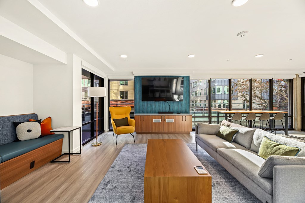 A modern living room with a grey sofa, a yellow chair and a wooden coffee table.