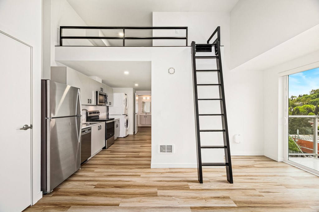 A black ladder is leaning against a white wall in a kitchen.