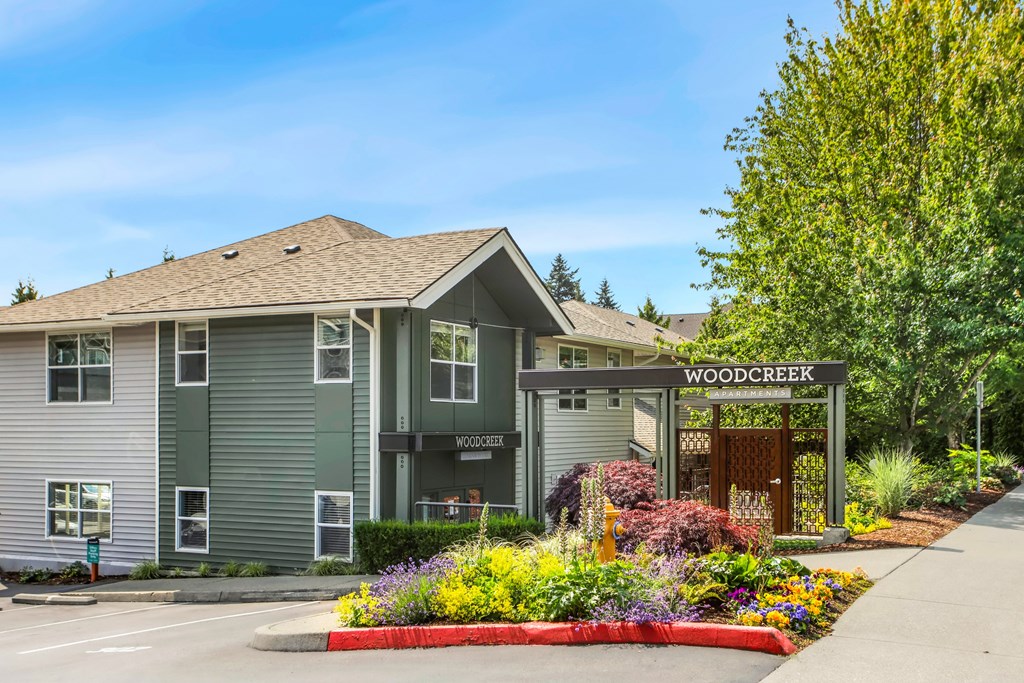 A building with a sign that says Woodcreek in front of it.