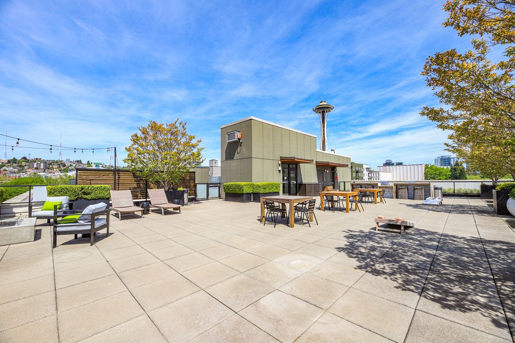 a patio with chairs and tables and a building in the background