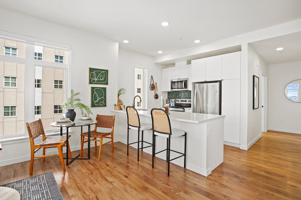 A kitchen with a dining table and chairs.