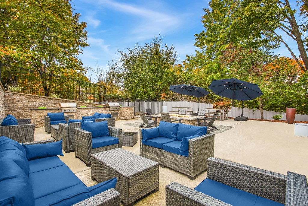 A patio with blue cushions and wicker furniture.