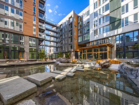 A modern building with a pool in front.