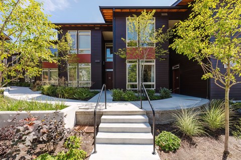 A modern house with a staircase leading to the front door.