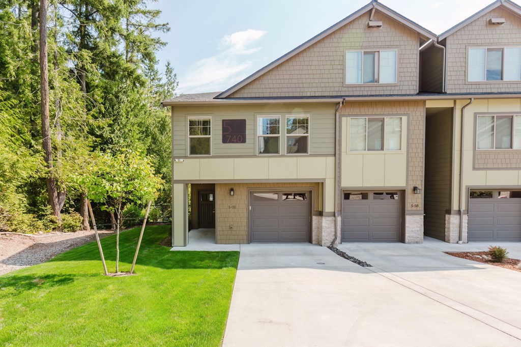 A two-story house with a garage and a driveway.