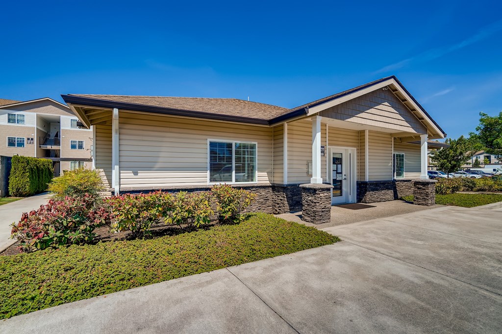 A beige house with a brown roof and a white door.