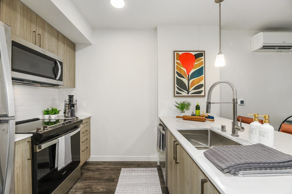 a kitchen with a sink and a stove and a microwave