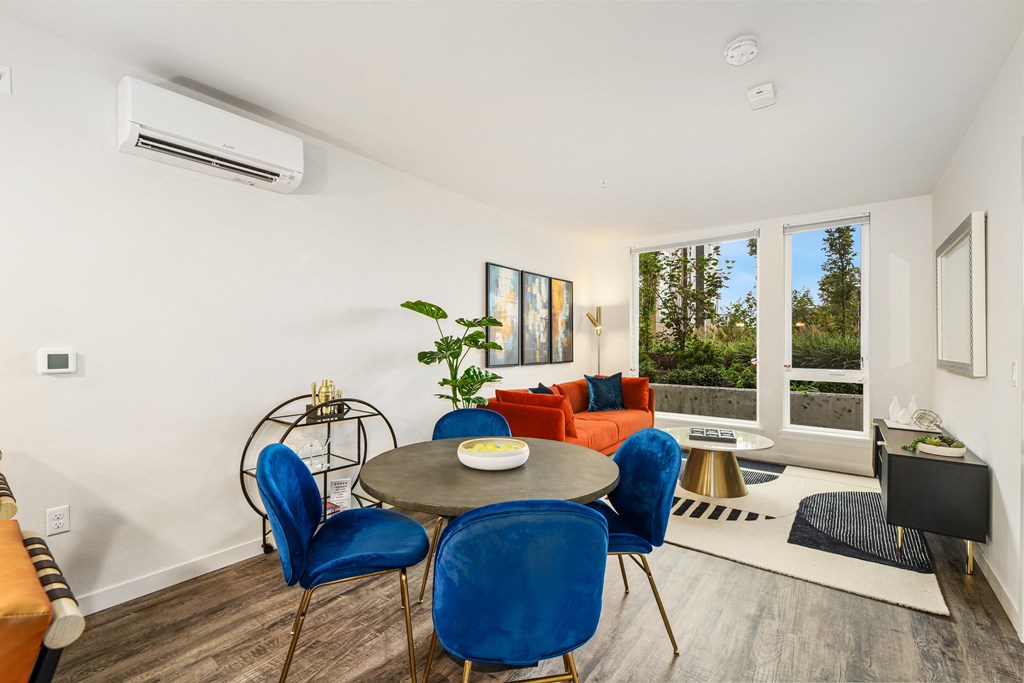 a living room with a round table and blue chairs
