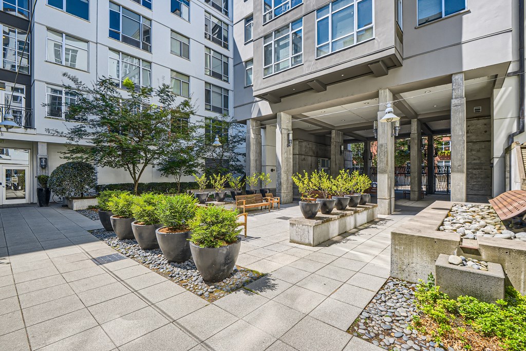 a courtyard with potted plants in front of a building