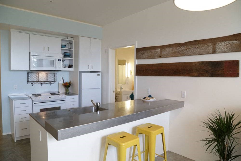 a kitchen with a counter and yellow bar stools