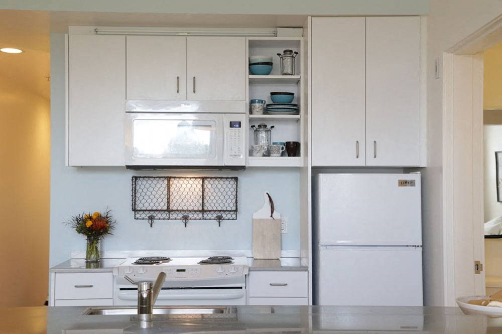 a white kitchen with a stove and a refrigerator
