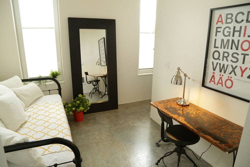 a bedroom with a bed and a desk and a mirror