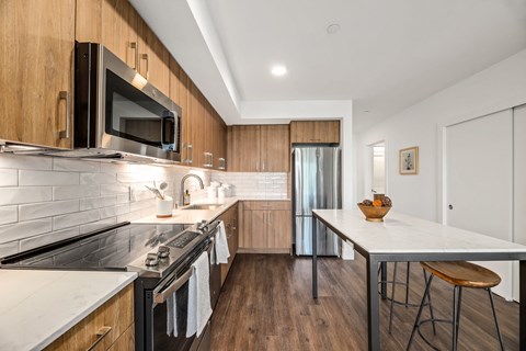 a modern kitchen with stainless steel appliances and wooden cabinets