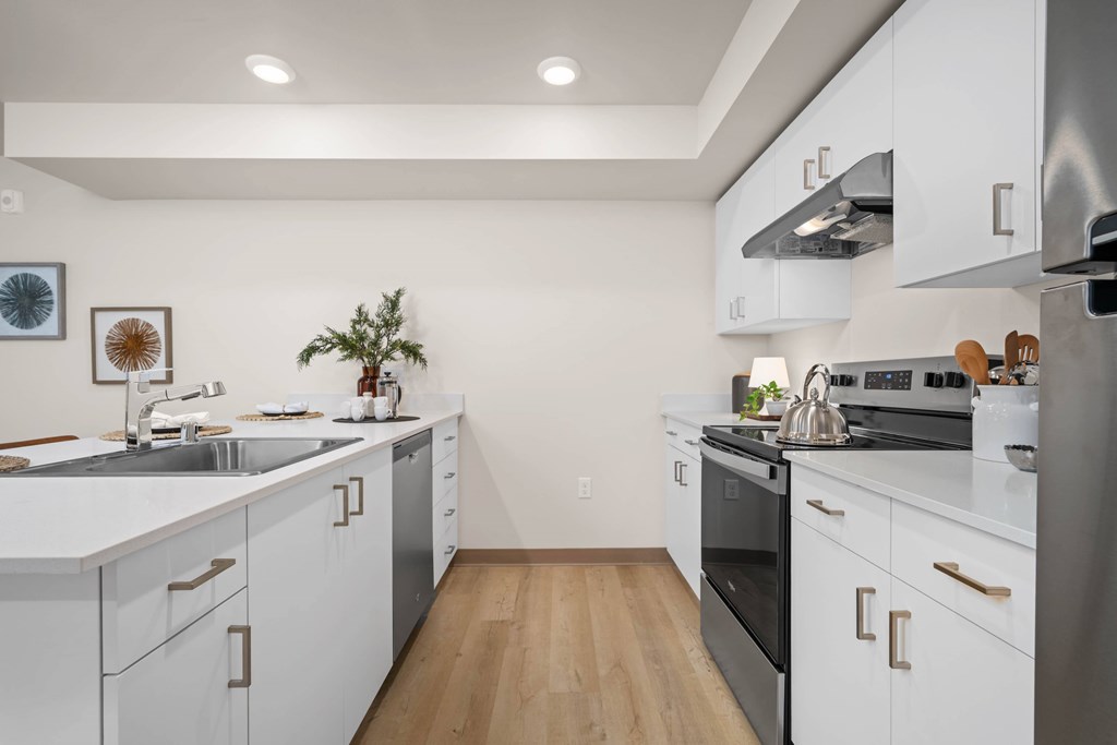 A modern kitchen with white cabinets and stainless steel appliances.