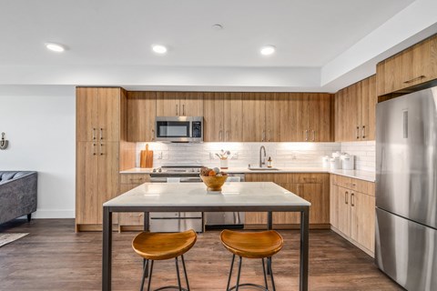 a kitchen with wooden cabinets and stainless steel appliances and a marble counter top