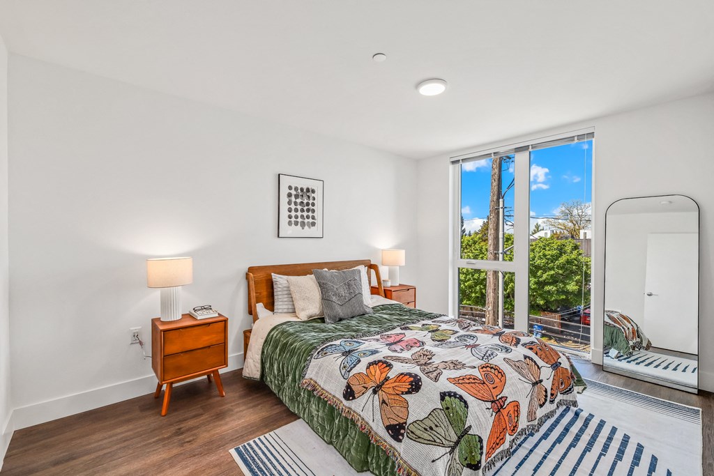 a bedroom with a bed and a large window