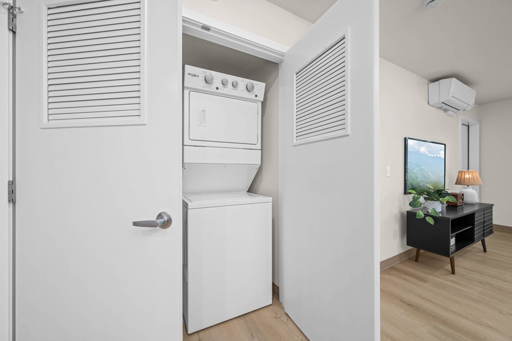 A white oven and dishwasher are in a kitchen with a wooden floor.