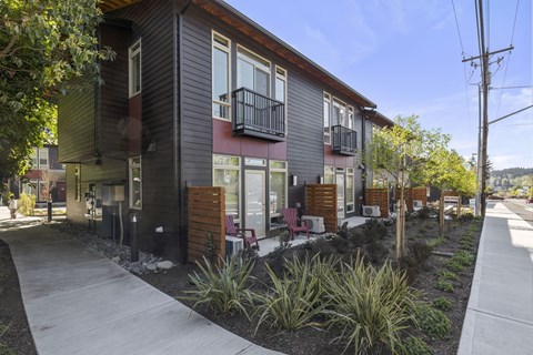 A modern two-story apartment building with a balcony on the second floor.