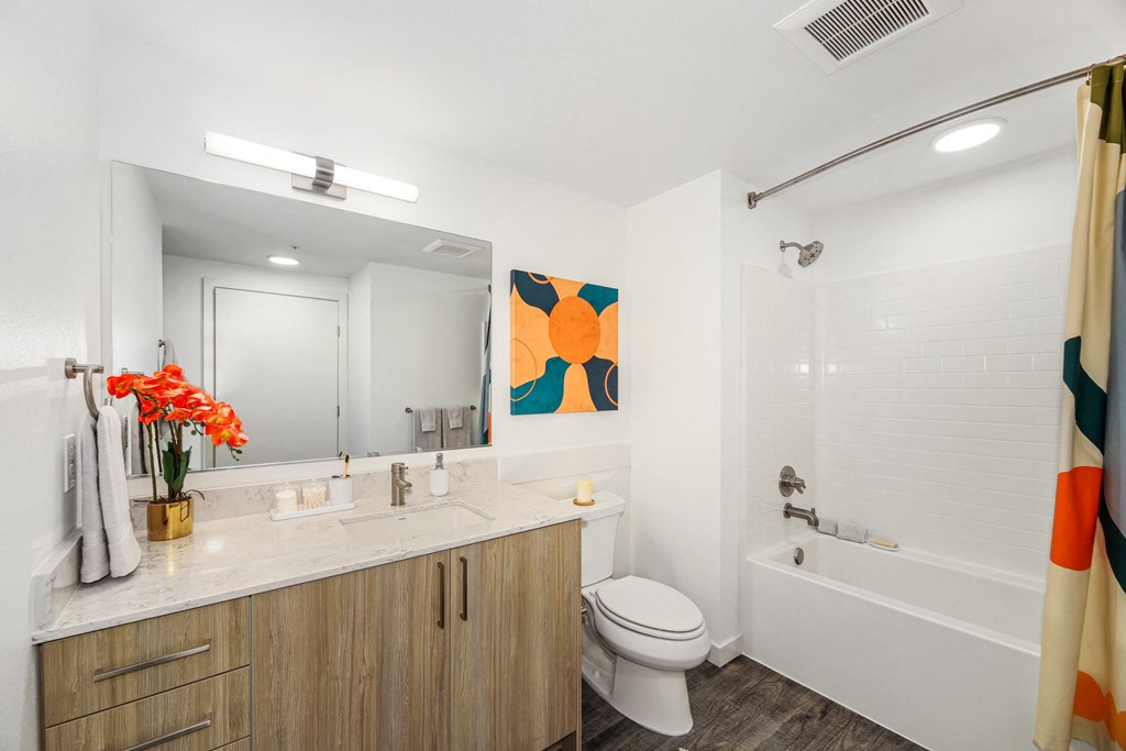 a bathroom with a toilet sink and shower and a mirror