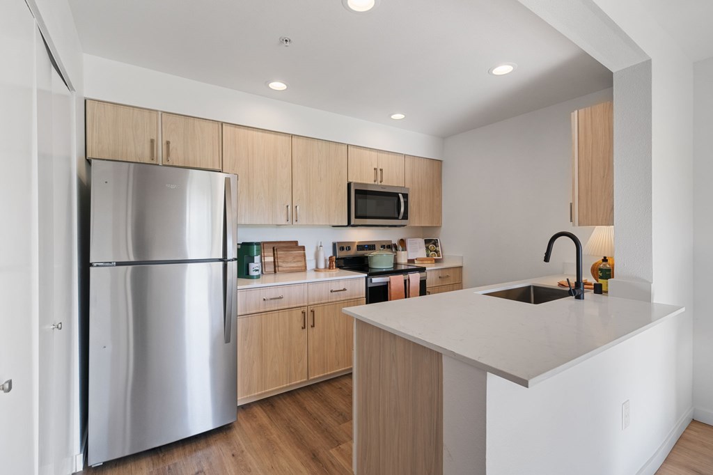 A modern kitchen with wooden cabinets and stainless steel appliances.