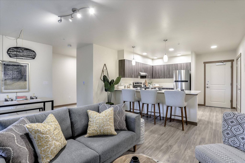 a living room with a couch and a kitchen with a bar