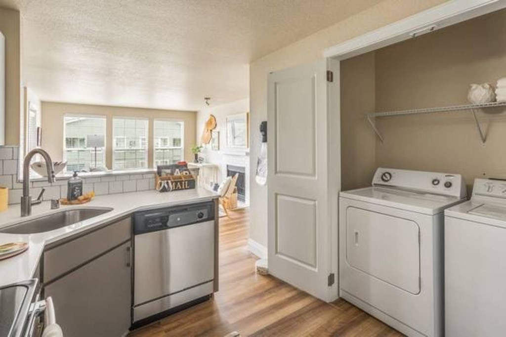 A kitchen with a washing machine and dryer in the laundry room.