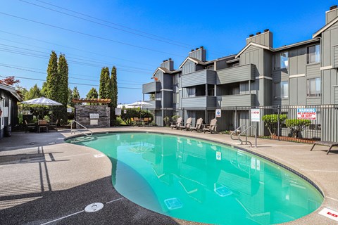 A swimming pool in front of a residential building.