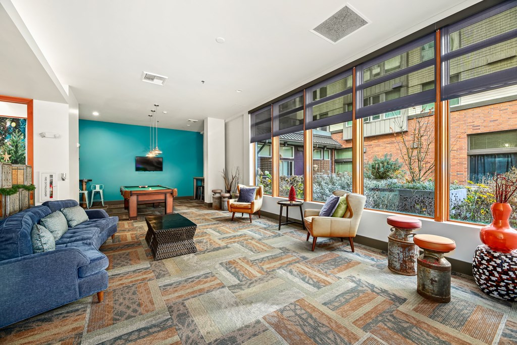 A living room with a blue couch and a rug with a pattern.