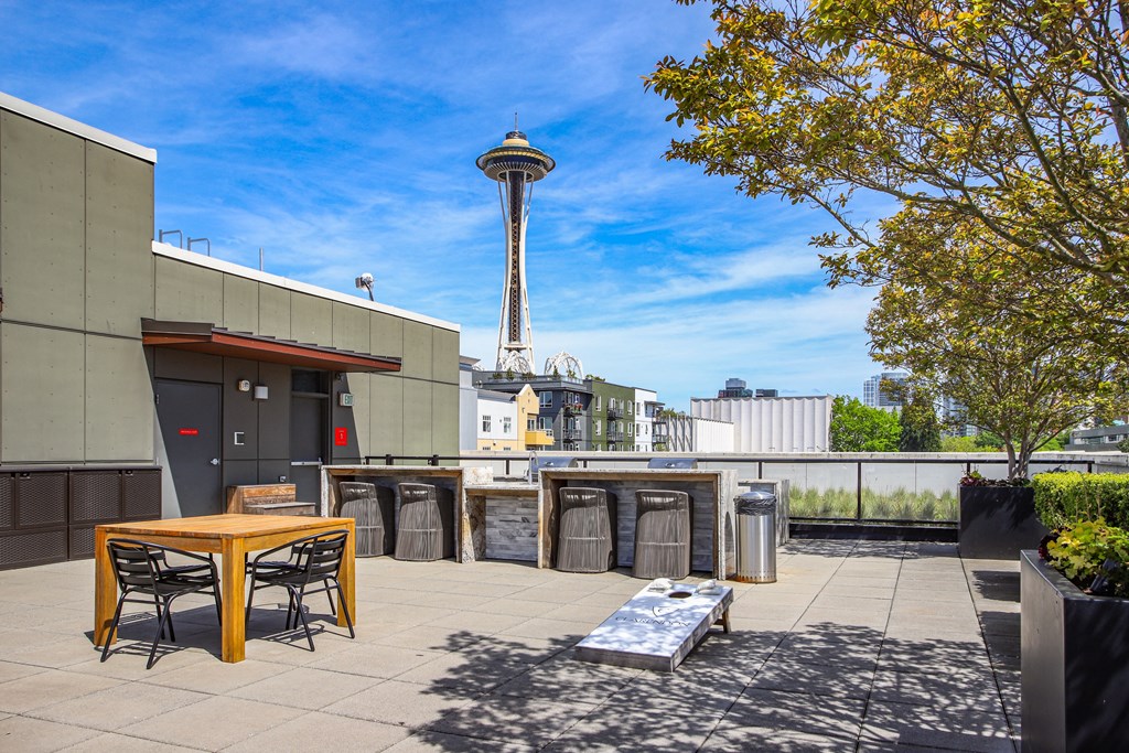 a patio with a table and chairs and a view of the space needle