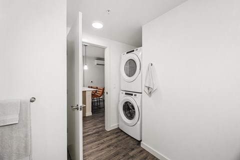 a white washer and dryer in a small laundry room with a door to