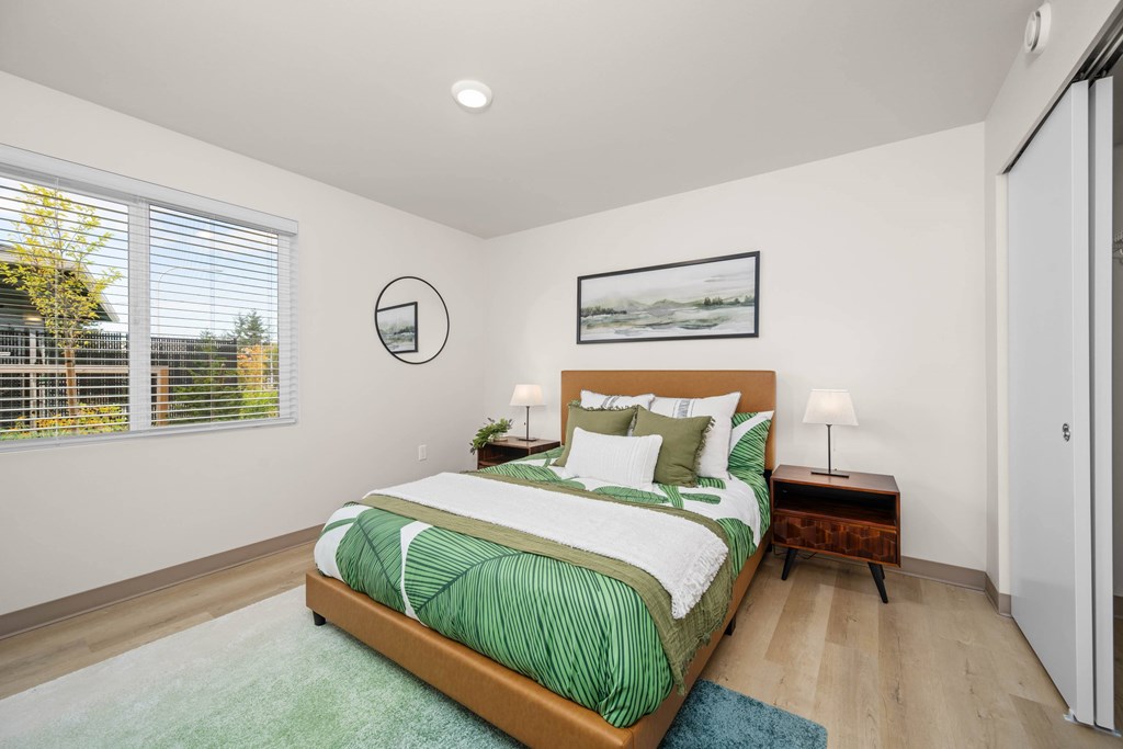 A bedroom with a large bed and a painting on the wall.