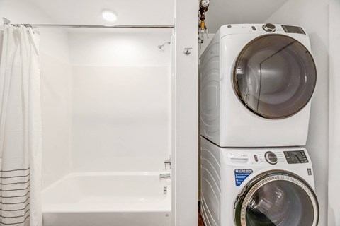 a washer and dryer in a laundry room next to a tub