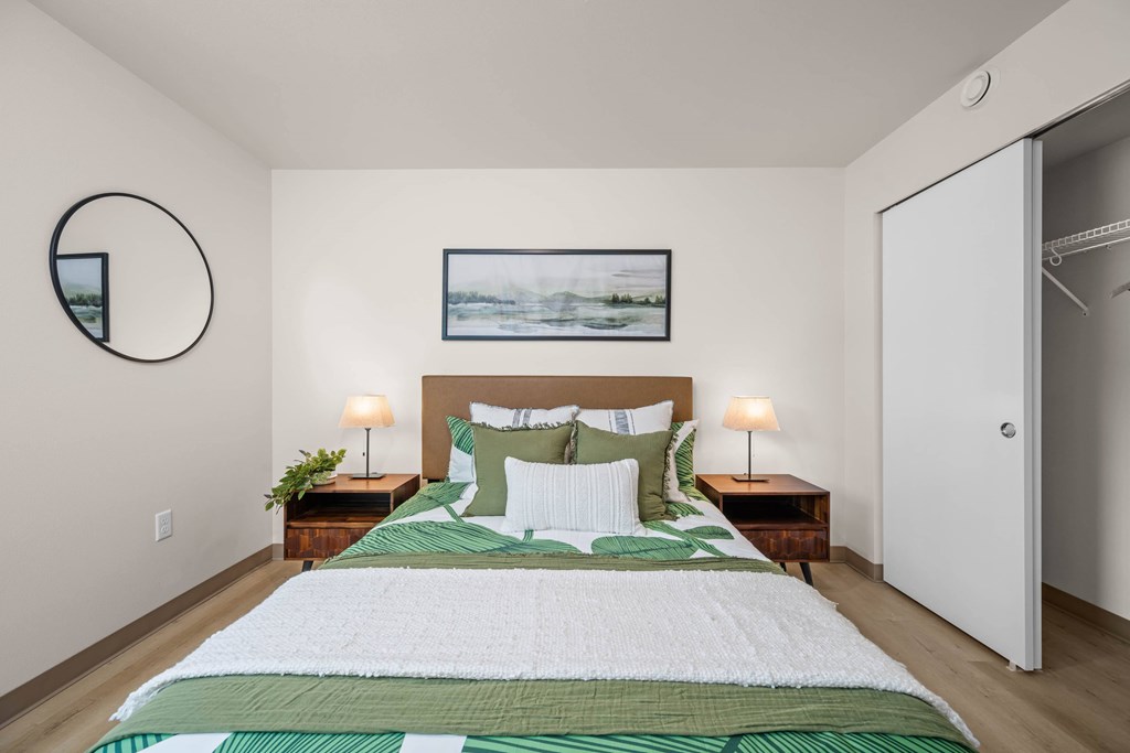 A bedroom with a large bed and a painting above it.