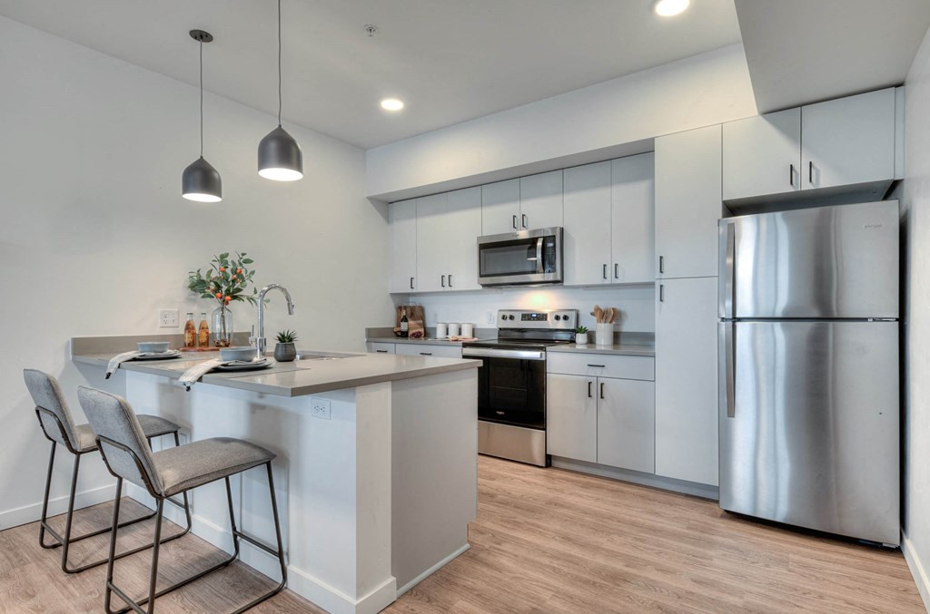 a kitchen with stainless steel appliances and an island with two stools