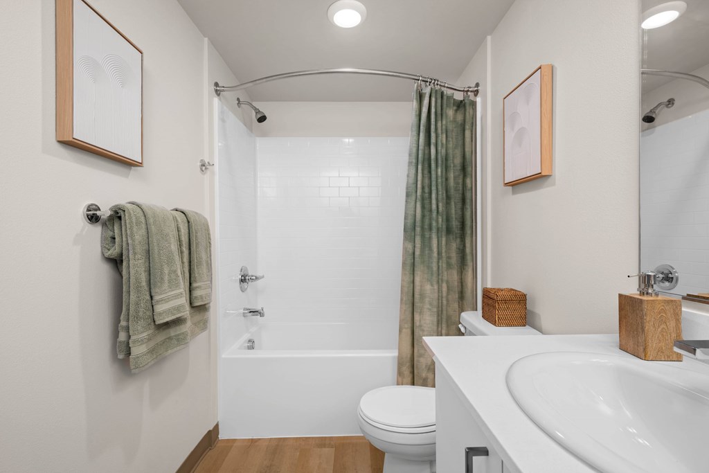 A white bathroom with a toilet, sink, and shower.