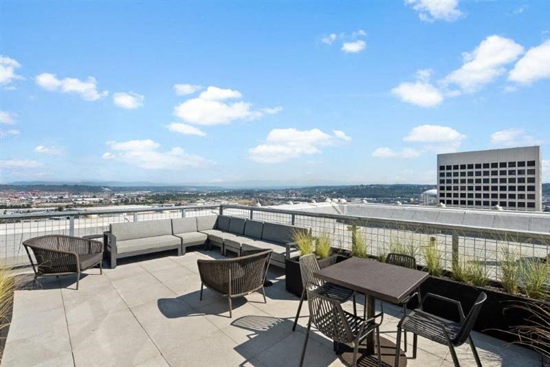 a patio with couches and tables on top of a building