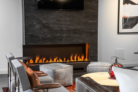 a living room with a fireplace and chairs and a table