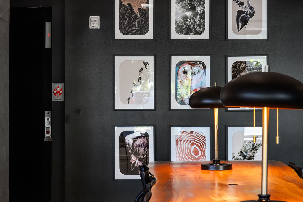 a desk with a lamp and pictures on the wall