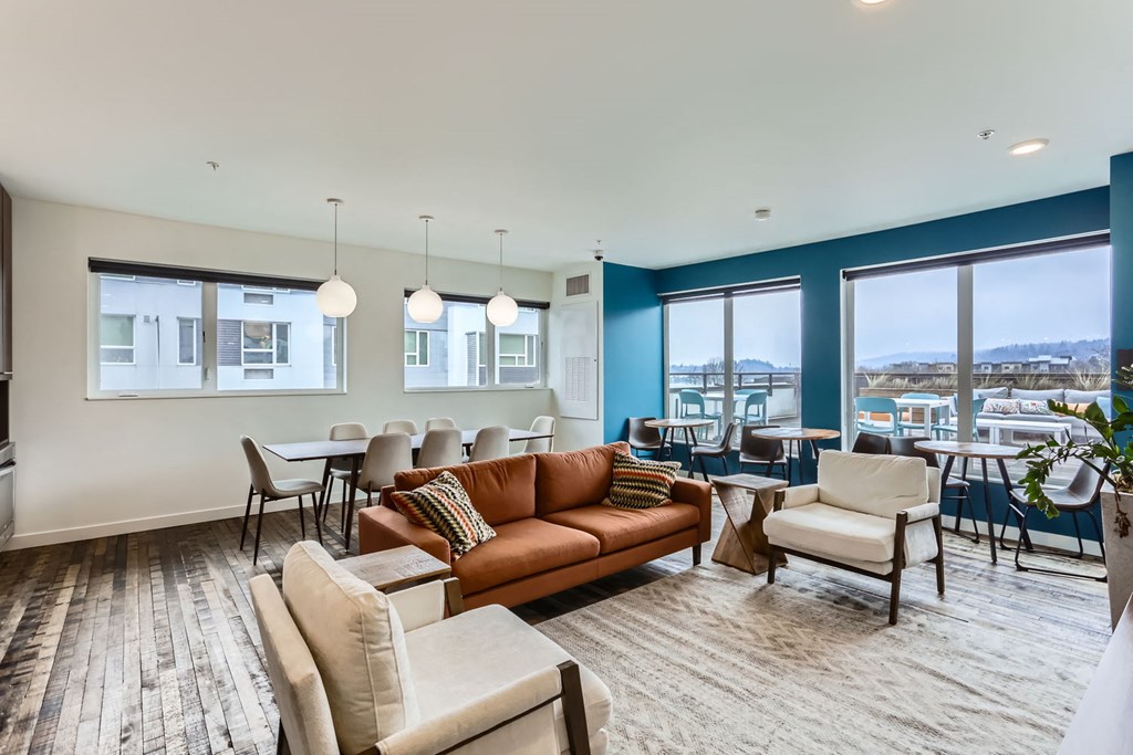 A living room with a couch, chairs, and a dining table.