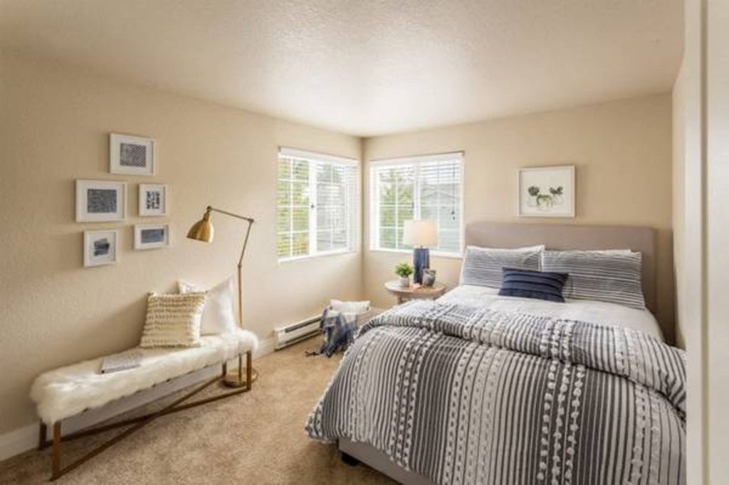 A bedroom with a large bed and a bench.