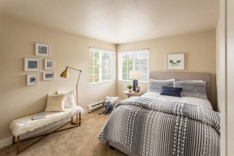 A bedroom with a large bed and a bench.