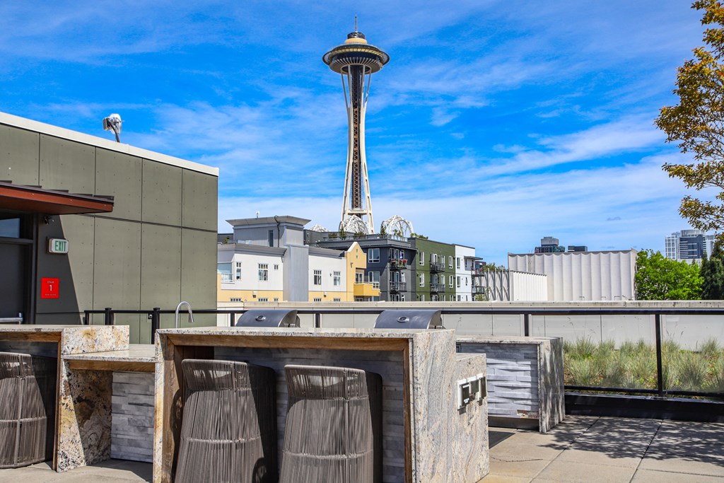 a rooftop bar with a view of the space needle in the city