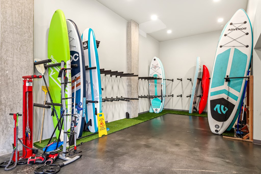 A room with a row of surfboards on the wall.