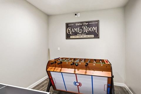 A game room with a pool table and a sign on the wall.