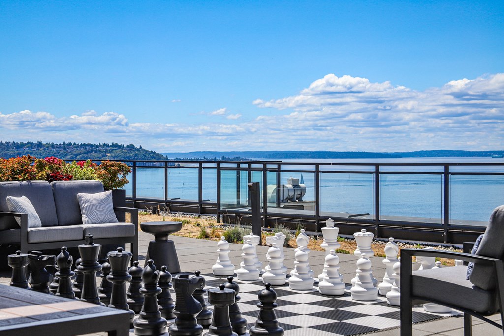 a large chess board on a balcony overlooking the water