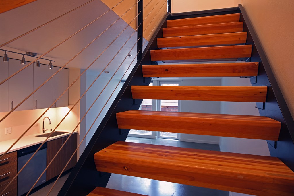 the stairs are made of wood and steel and lead up to the second floor