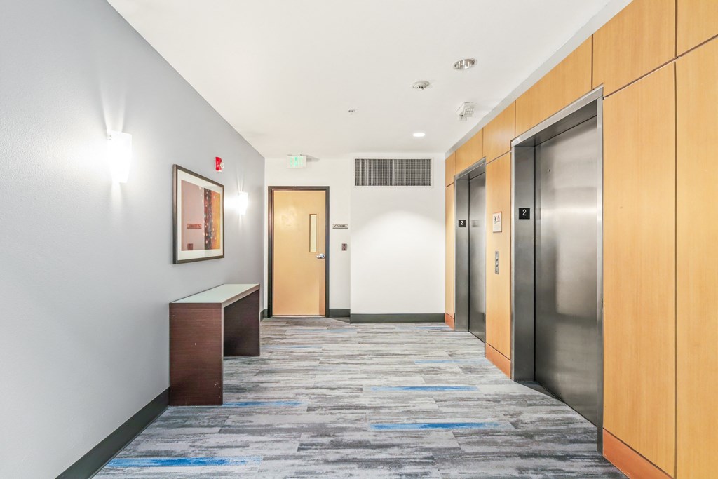 a hallway with elevators and doors in an office building