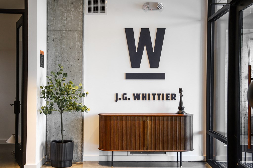 a living room with a wooden cabinet and a large letter on the wall