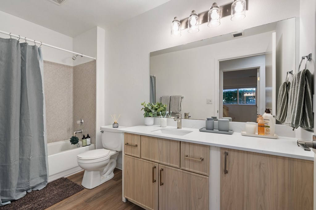 A bathroom with a white toilet, a white sink, and a white countertop.